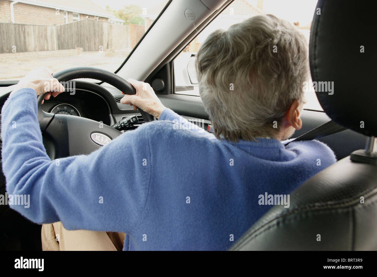 Femme âgée conducteur au volant d'une voiture roulant soigneusement Banque D'Images