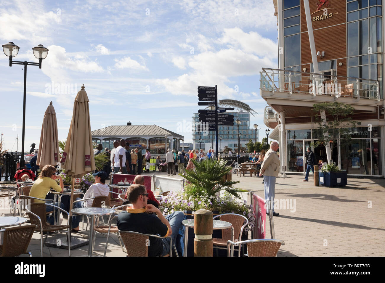 Les gens assis à l'extérieur en terrasses de cafés sur le bord de mer. Mermaid Quay, la baie de Cardiff, Glamorgan, Pays de Galles, Royaume-Uni Banque D'Images