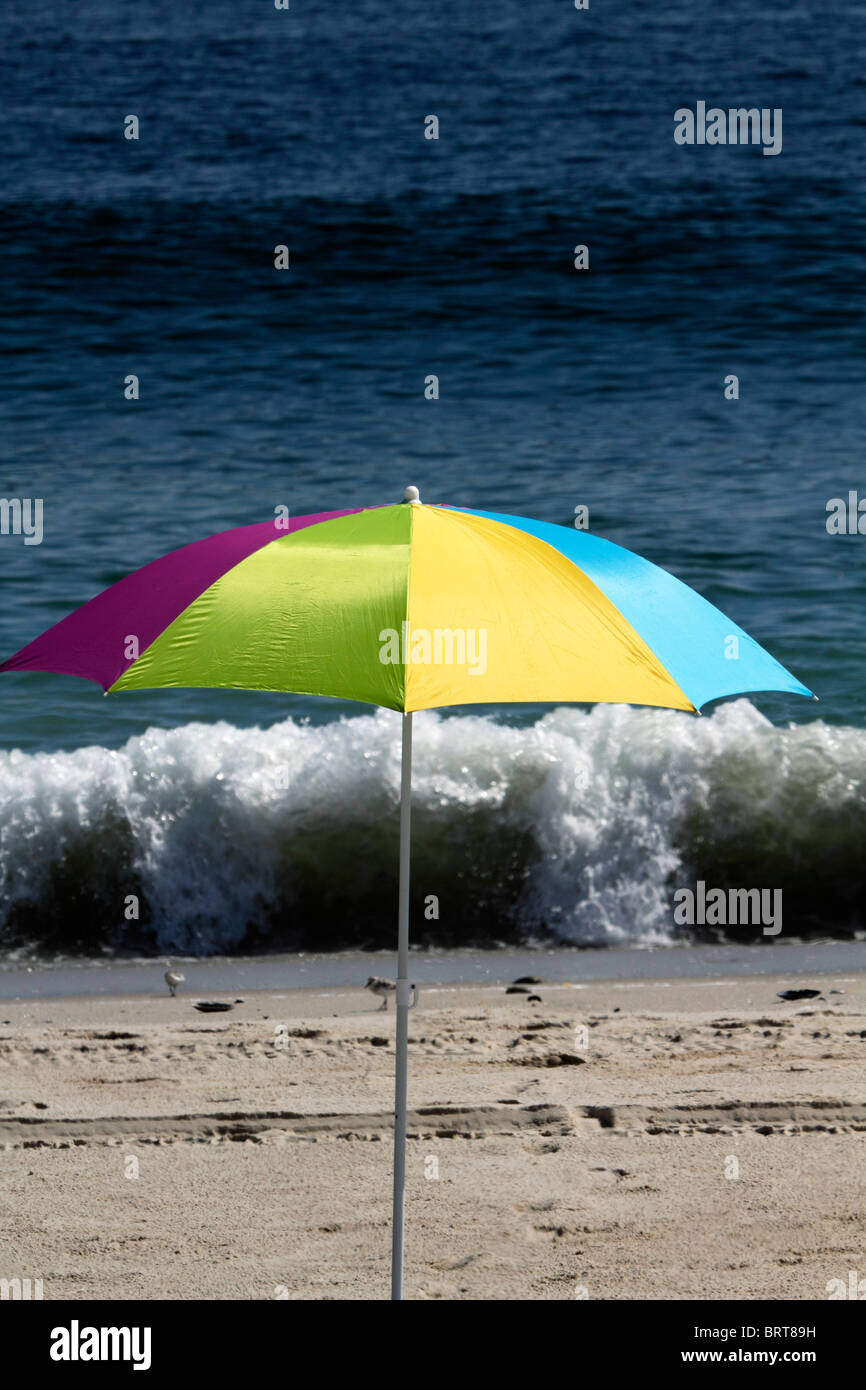 Parapluie de plage en face de vague déferlante. Lavalette, New Jersey, USA. Banque D'Images