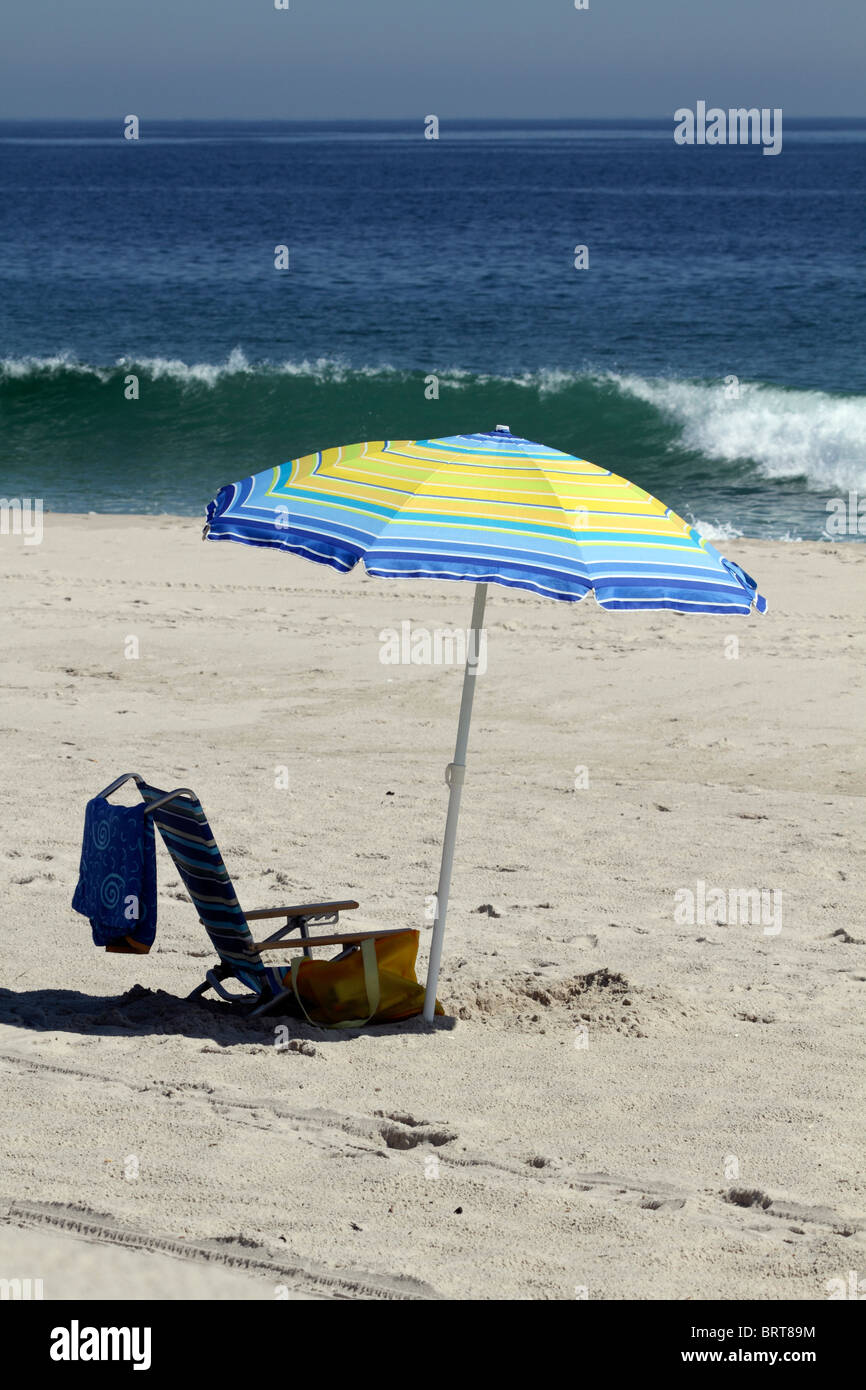 Parapluie de plage en face de vague déferlante. Lavalette, New Jersey, USA. Banque D'Images