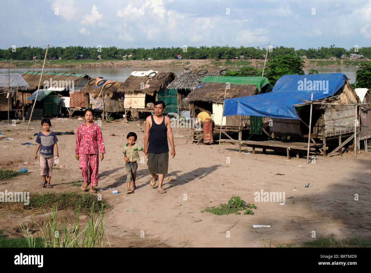 Une famille quitte un bidonville de squatteurs où les gens vivent dans la pauvreté sur la rive d'un fleuve du Mékong dans la région de Kampong Cham, au Cambodge. Banque D'Images