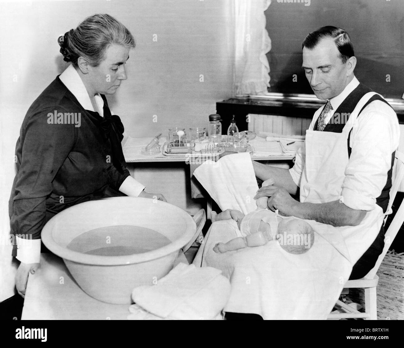 Un homme soins bébé pratiques, image historique, ca. 1928 Banque D'Images