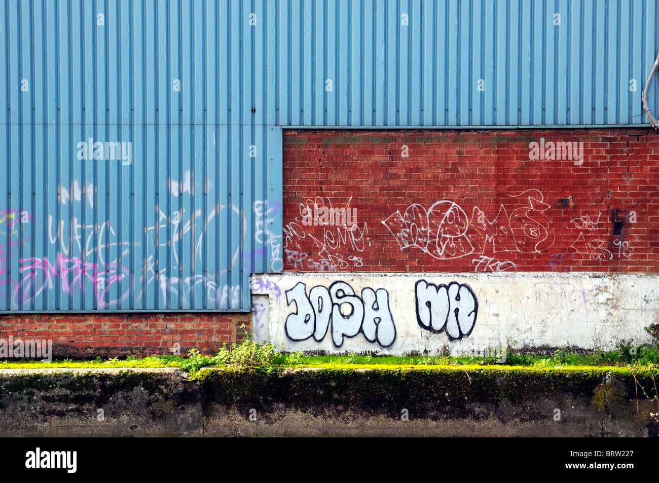 Blue metal et mur de brique rouge avec graffiti Banque D'Images