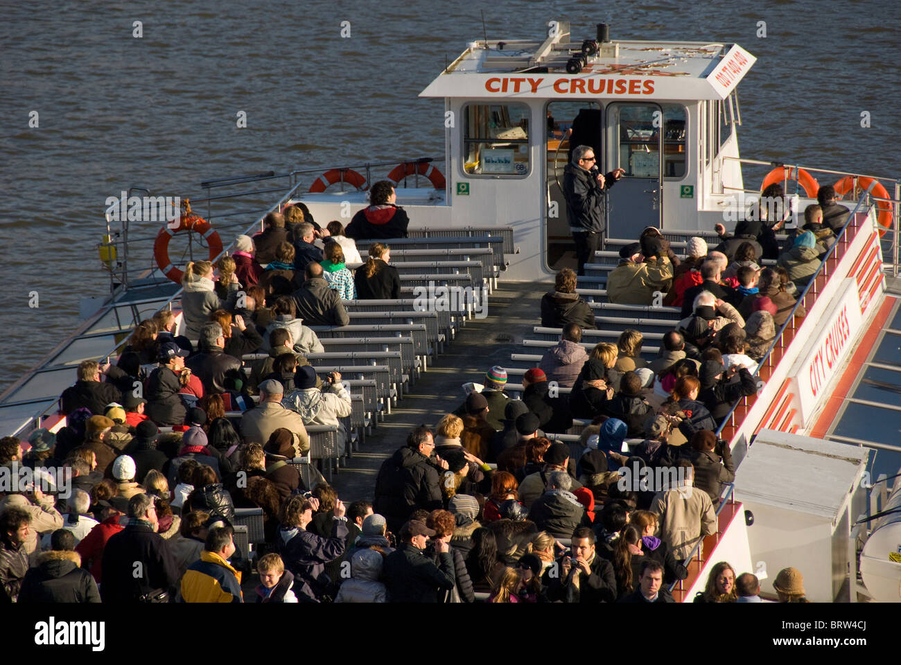 Personnes sur un bateau de croisière de la ville avec guide, Thames, London, UK Banque D'Images