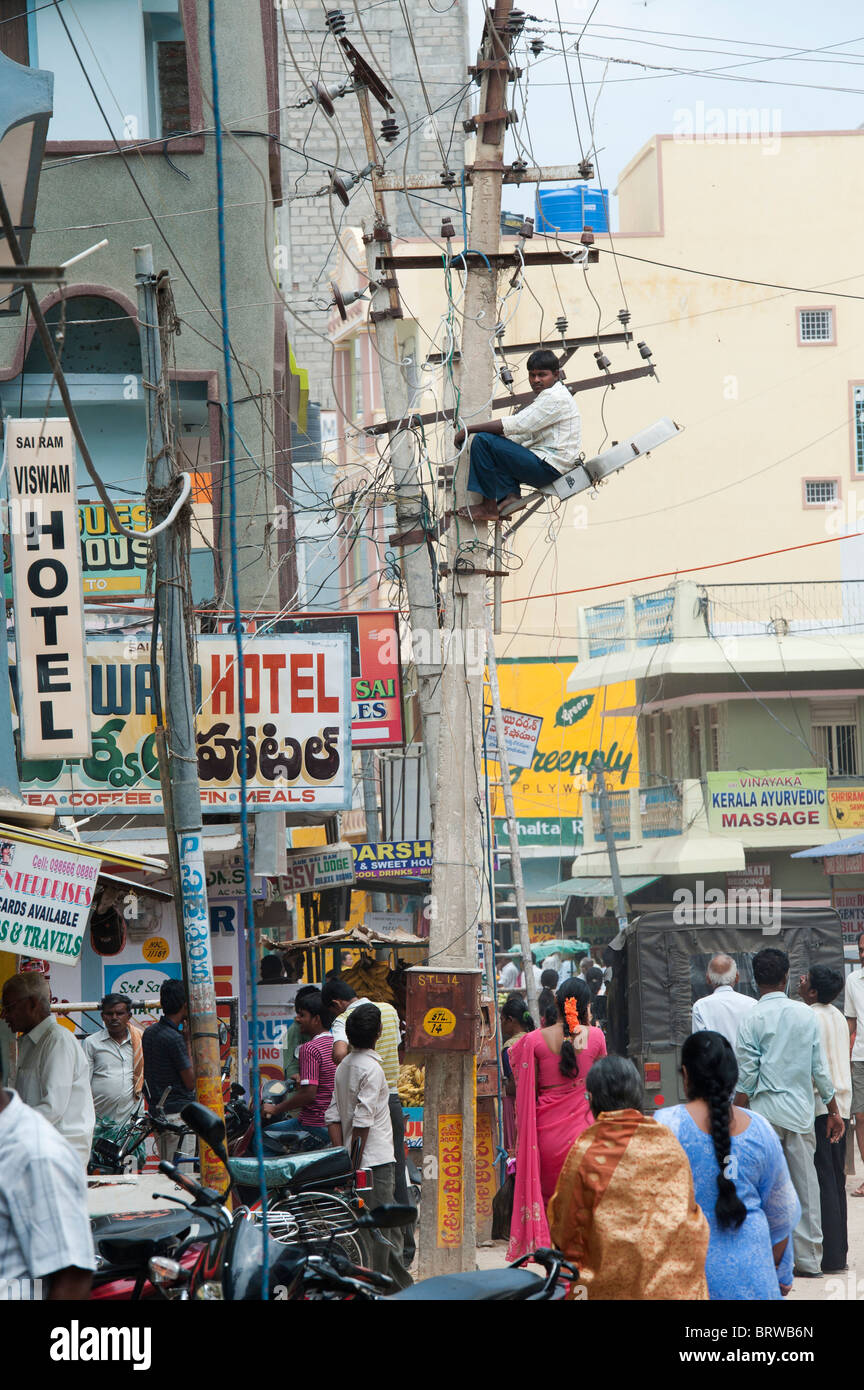 Electrician indiennes d'un pylône d'électricité dans les rues de Puttaparthi, Andhra Pradesh, Inde Banque D'Images