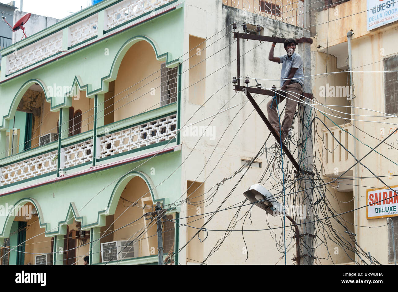 Electrician indiennes d'un pylône d'électricité dans les rues de Puttaparthi, Andhra Pradesh, Inde Banque D'Images