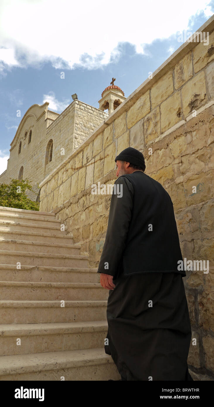 La Syrie Mgr Christo de monter les escaliers de son Saint George's monastery, Almishtaya, Wadi al-Nasarah, vallée des Chrétiens Banque D'Images