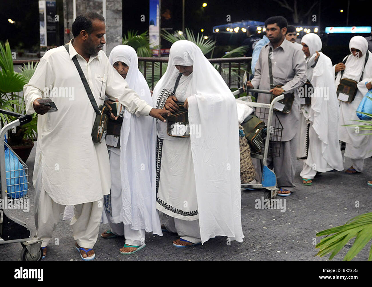 Les musulmans pakistanais stand dans la file d'attente qu'ils partent pour le pèlerinage annuel en Arabie Saoudite, à l'aéroport de Karachi Banque D'Images