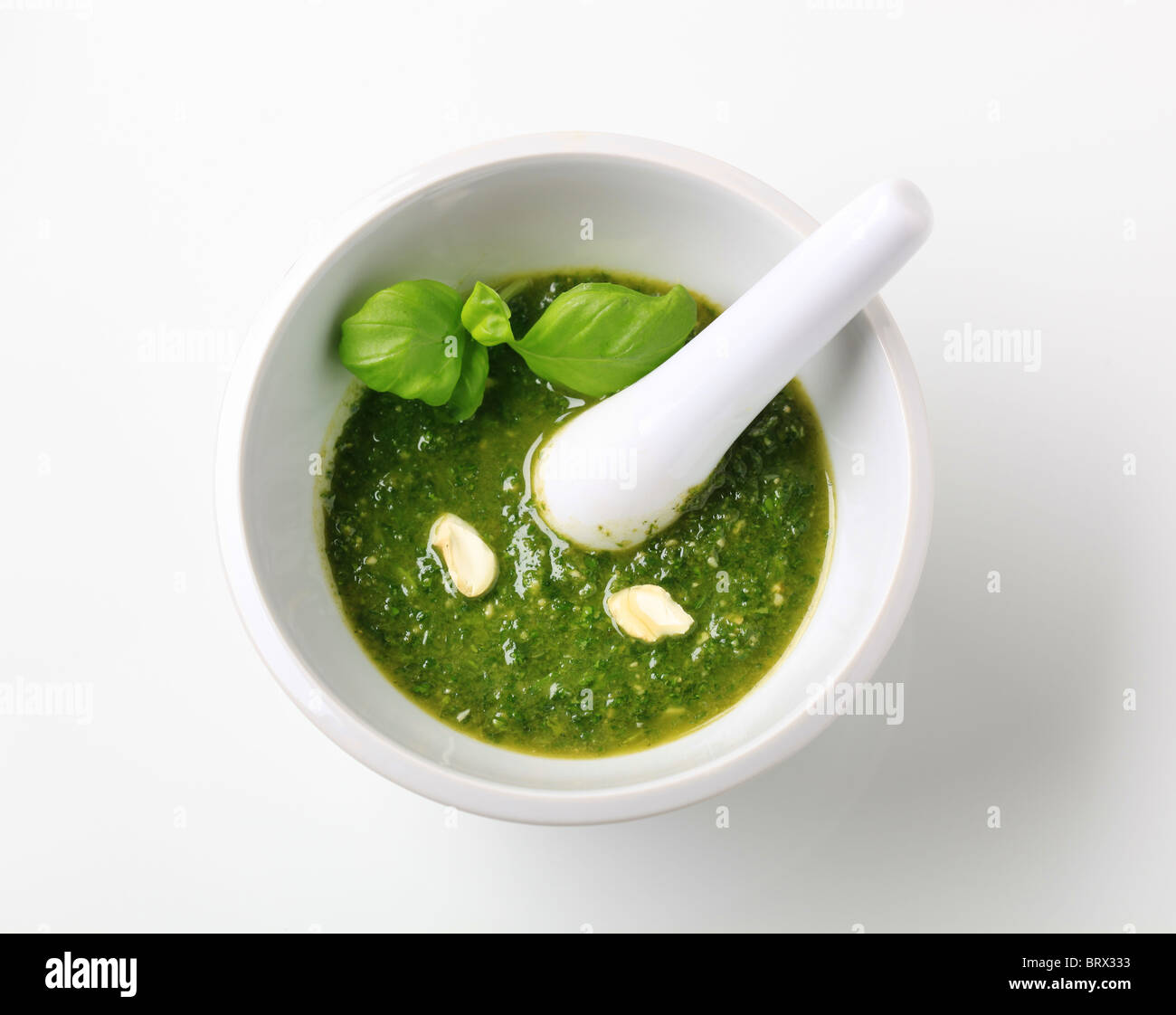 Pesto de basilic avec les noix de cajou écrasées dans un mortier Banque D'Images