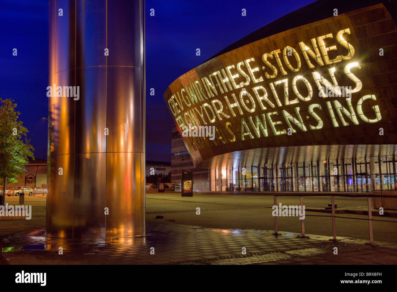 Avant de Cardiff Millennium Centre complexe artistique et tour de l'eau fontaine illuminée la nuit. L'architecture moderne dans la baie de Cardiff, Glamorgan, Pays de Galles, Royaume-Uni. Banque D'Images