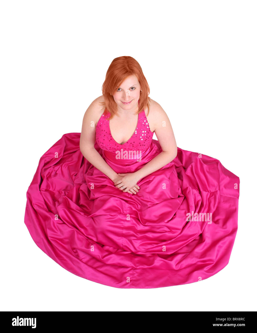 Jeune fille rousse portant une robe de bal rose isolated over white Banque D'Images