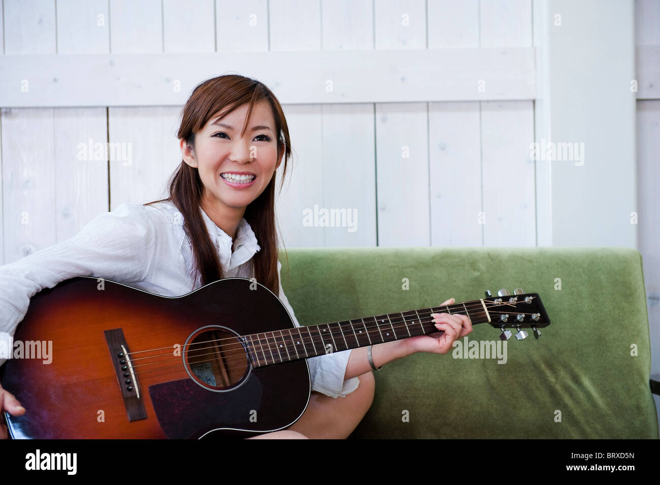 Jeune femme avec guitare acoustique Banque D'Images