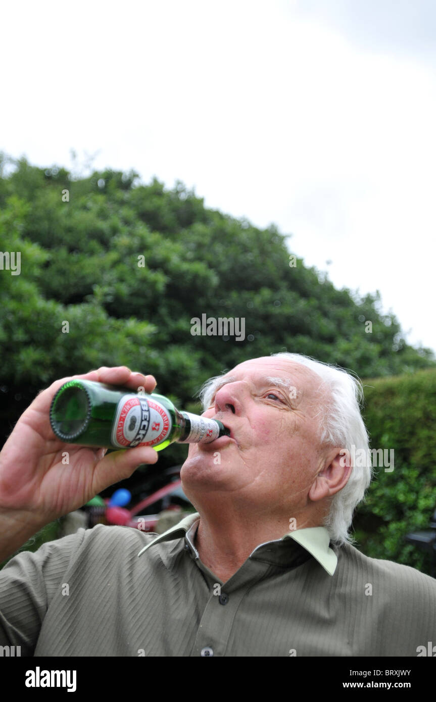 Senior man drinking beer de la bouteille Banque D'Images