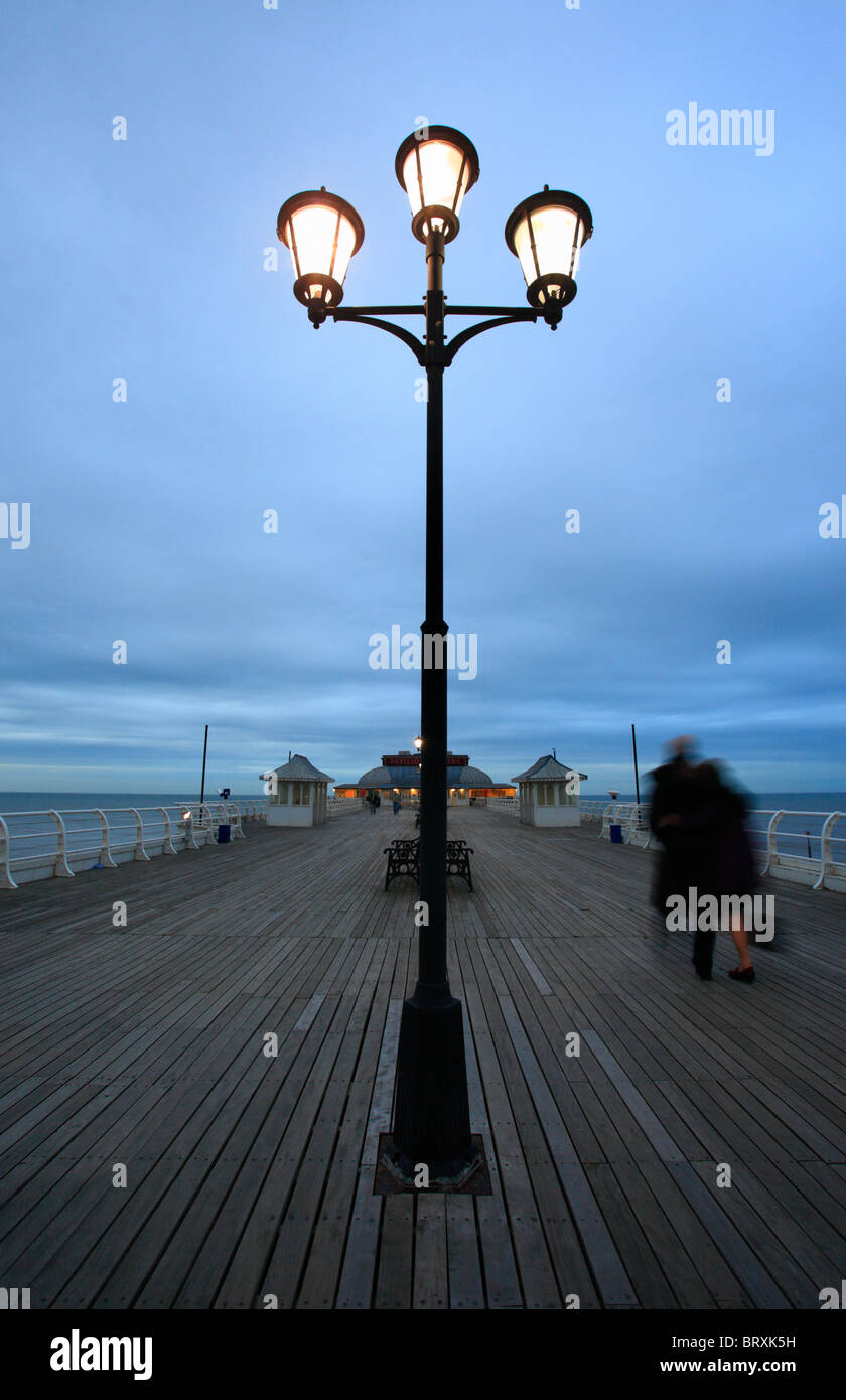 Sur la jetée de Cromer Norfolk Coast en début de soirée avec un couple en train de marcher. Banque D'Images