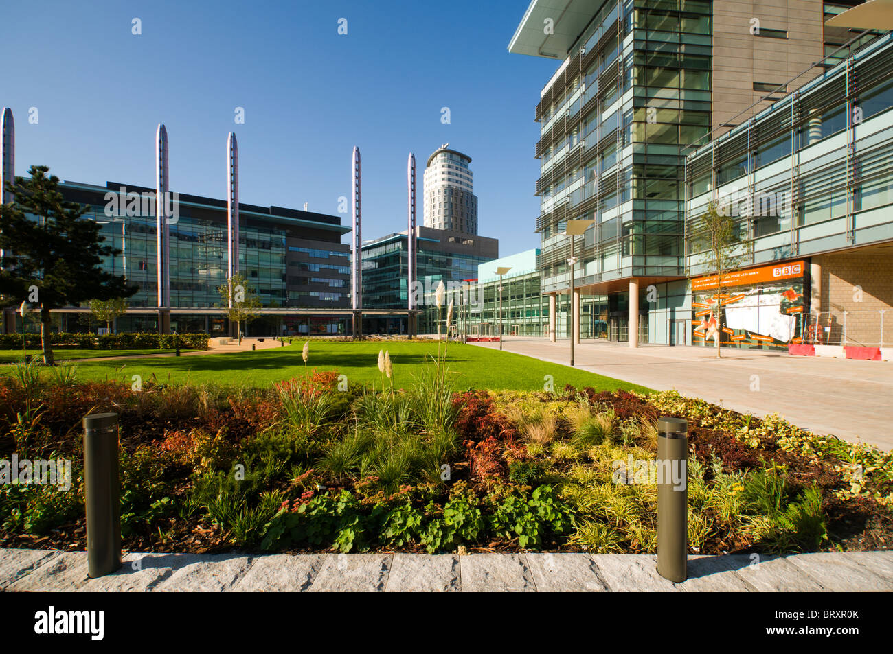 Les bâtiments et l'éclairage MediaCityUK colonnes à partir de la 'Green' de la piazza. Salford Quays, Manchester, Royaume-Uni. Banque D'Images