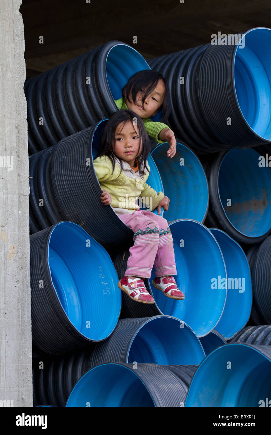 Deux jeunes filles de la province de Yunnan Chine jouant sur un site de construction Banque D'Images