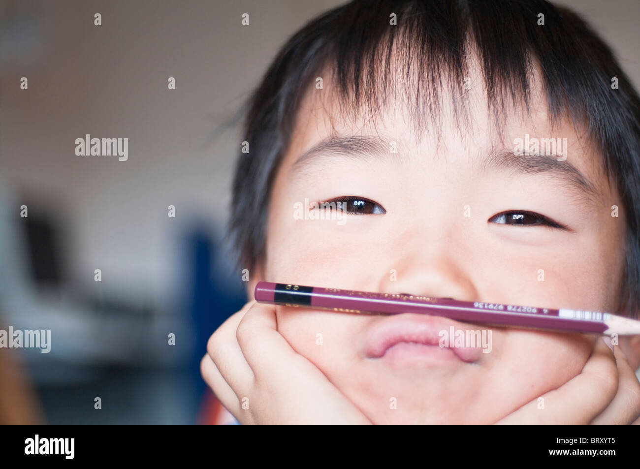 Boy balancing pen entre les lèvres et le nez au Japon Banque D'Images