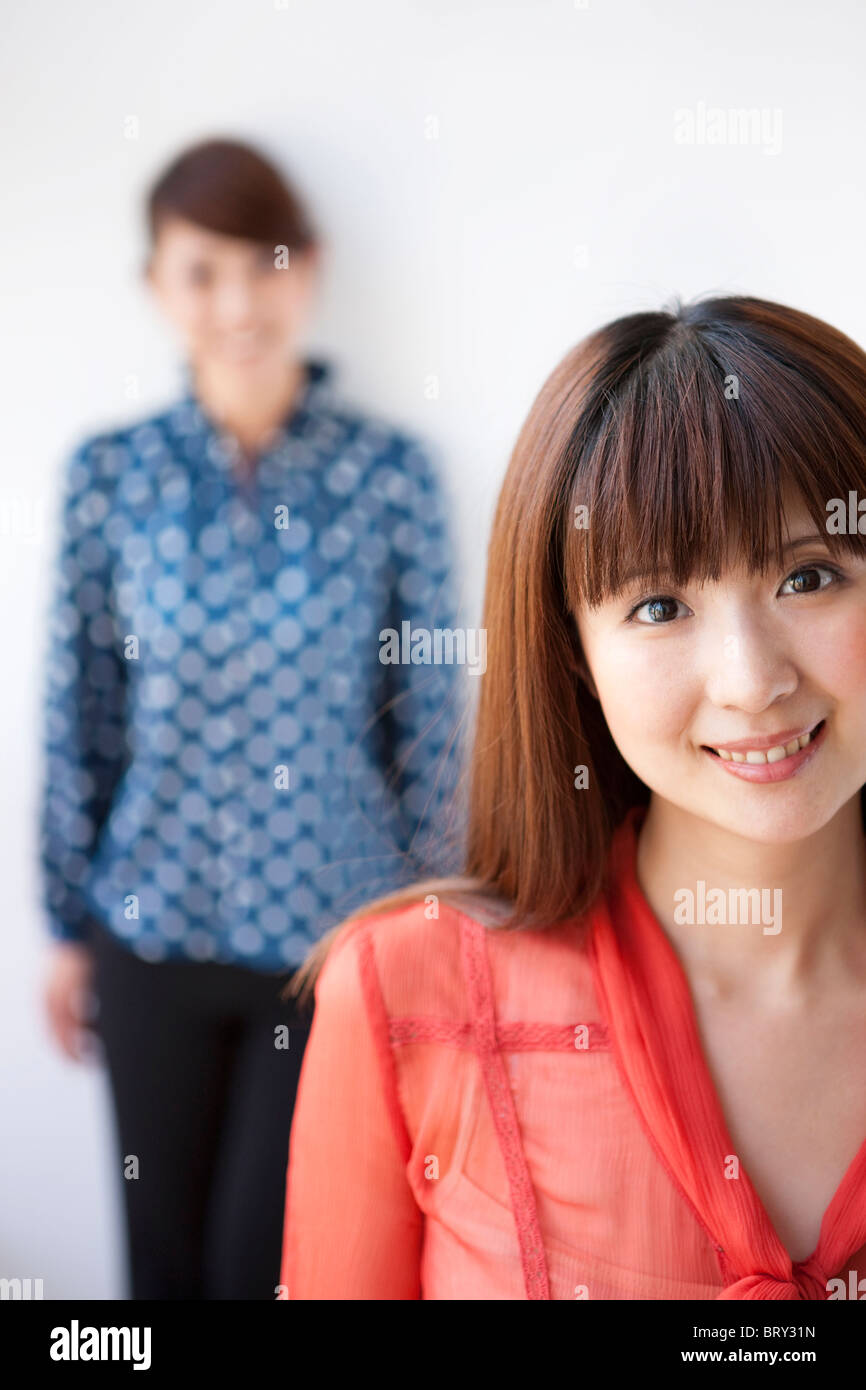 Portrait de jeunes femmes, smiling, fond blanc, differential focus Banque D'Images