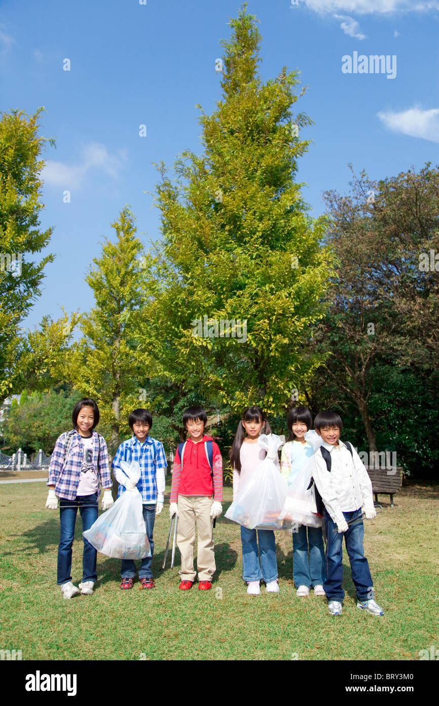 Portrait de l'école des enfants tenant des sacs pour le recyclage Banque D'Images