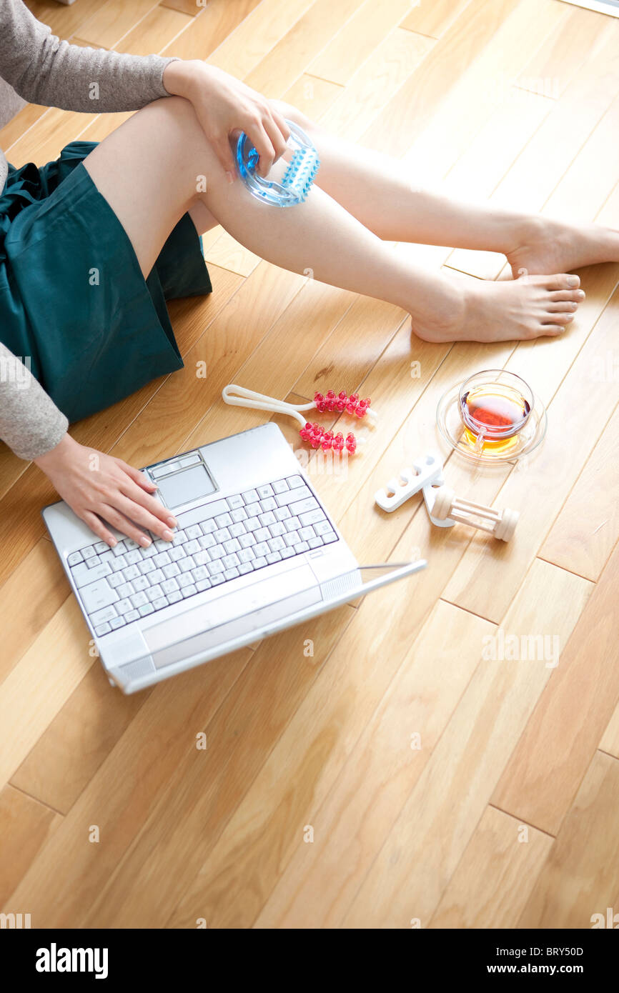 Jeune femme assise de marbre, using laptop Banque D'Images