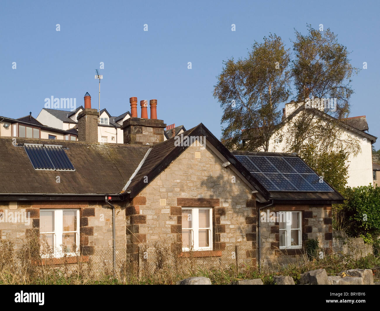 Chauffage de l'eau et de production d'énergie électrique photovoltaïque panneaux solaires sur un toit de maison à Grange Over Sands Cumbria Banque D'Images