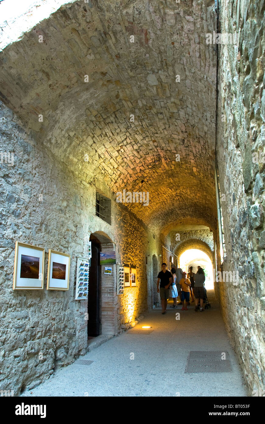 Passage voûté dans les murs du château et maintenant un métier et touristiques à pied à Castellina in Chianti, Toscane, Italie Banque D'Images