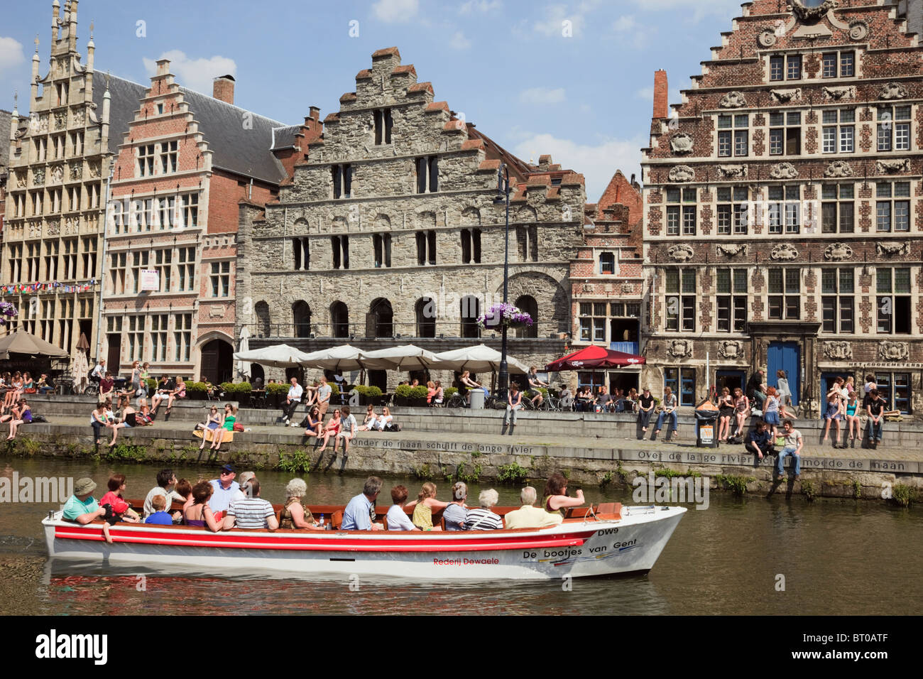 Graslei Site, Gand, Flandre orientale, Belgique, les touristes dans des bateaux touristiques sur la rivière Lys flamand médiéval avec maisons de guilde Banque D'Images