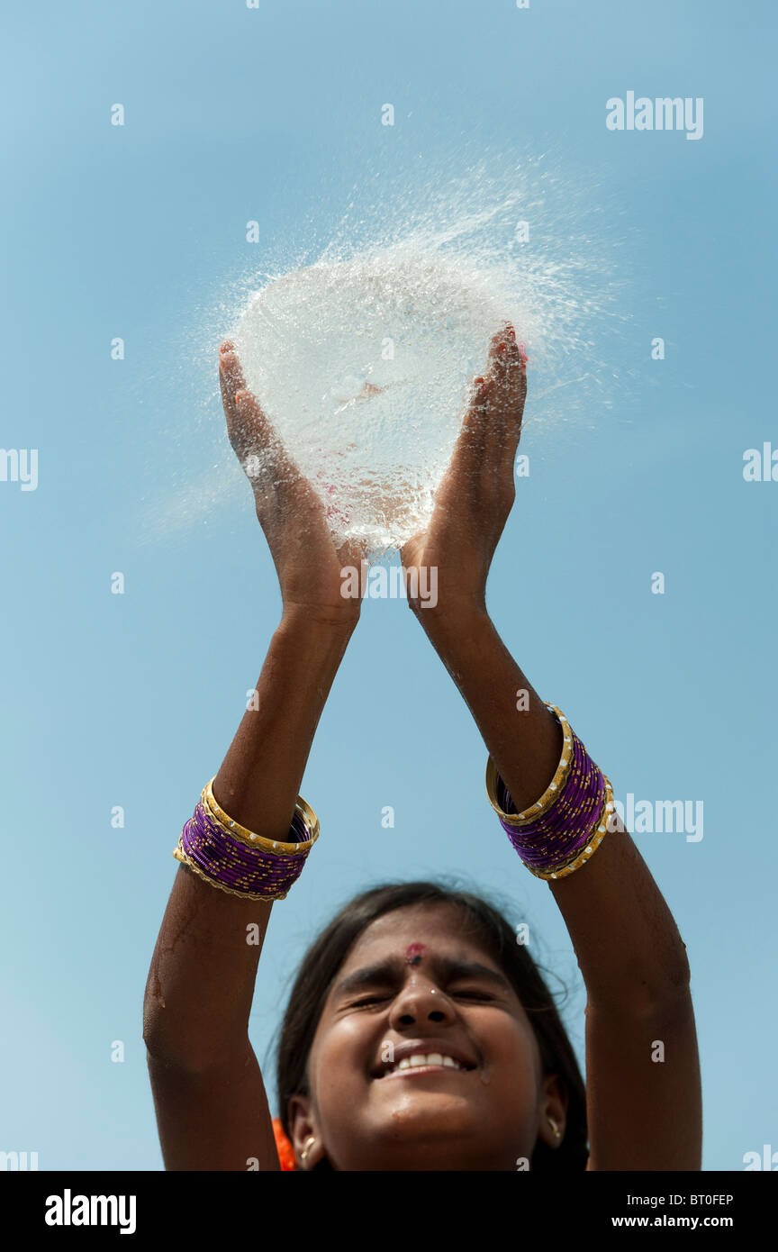 Indian girl holding a water balloon burst Banque D'Images