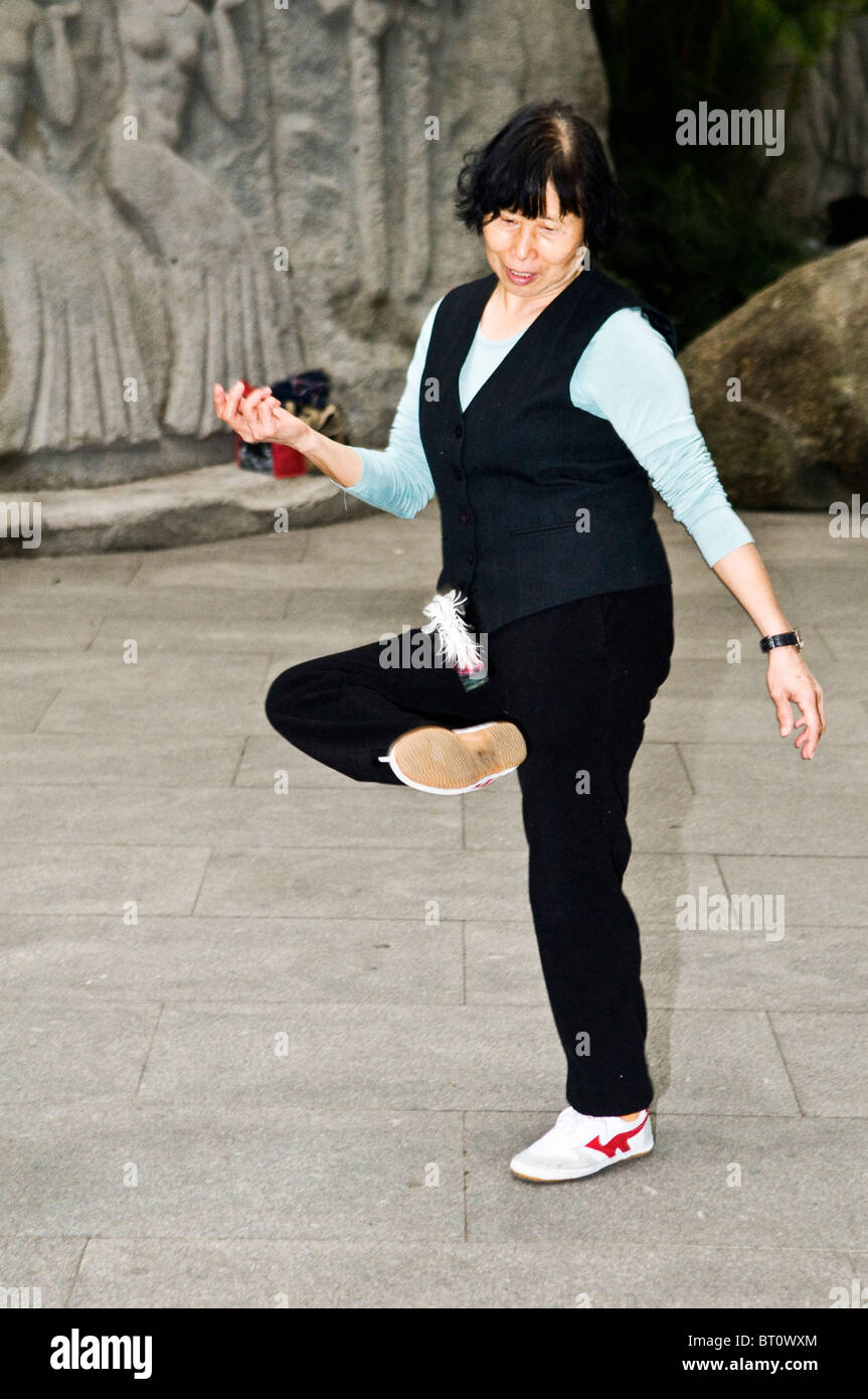 Une femme jouant de Jiànzi. De nombreux Chinois aiment jouer ou danser tôt le matin. Banque D'Images