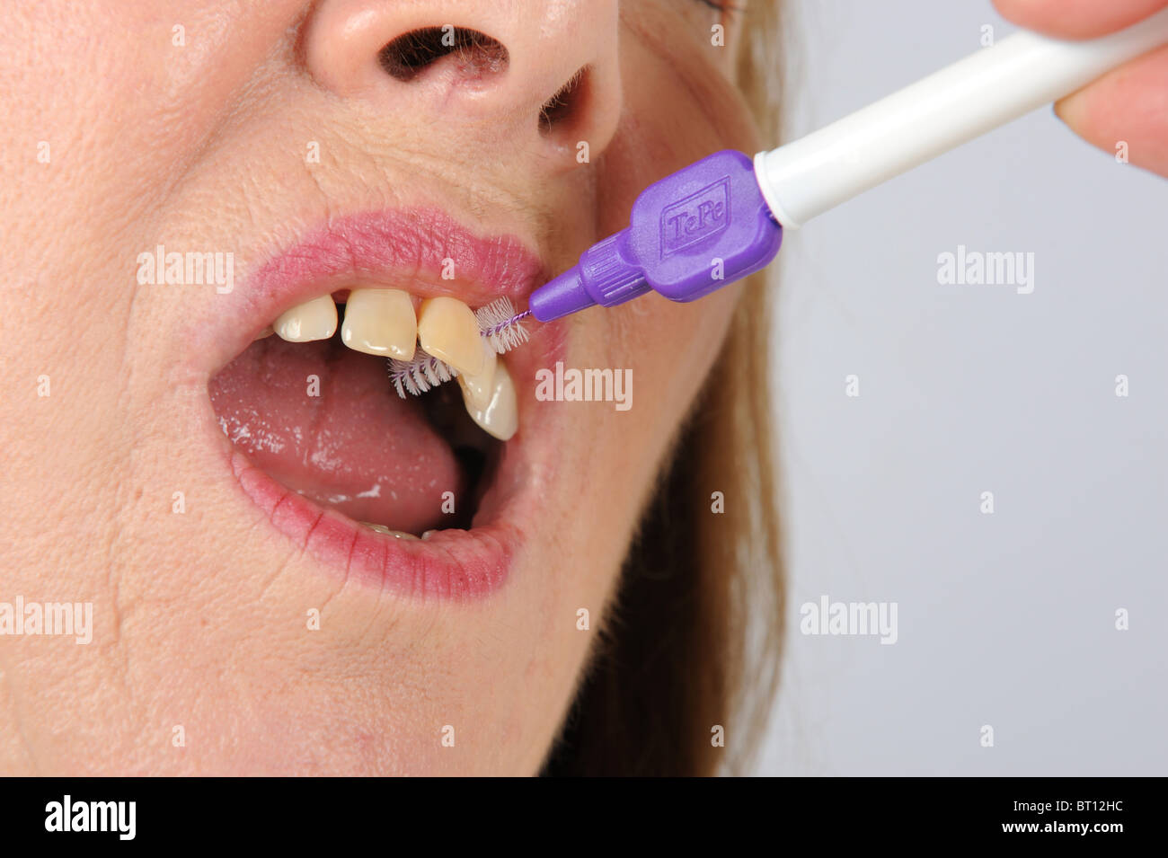 Femme d'âge moyen à l'aide de brosses dentaires afin de prévenir la maladie des gencives Banque D'Images