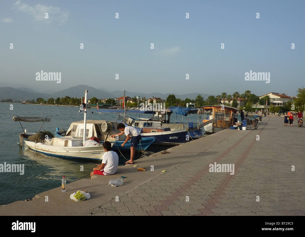 Des jeunes gens du quai de pêche au port de Fethiye en Turquie. Banque D'Images