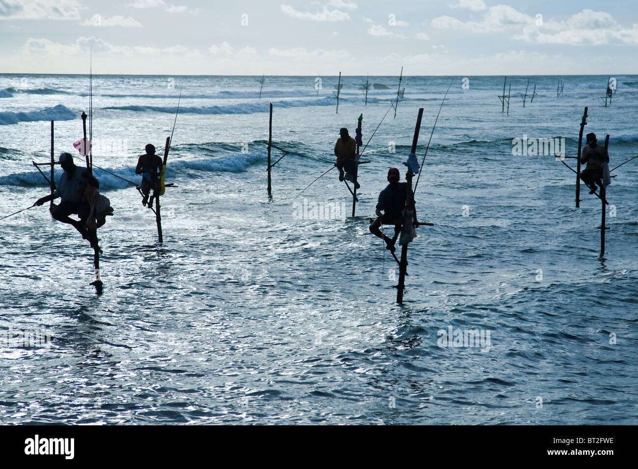 Pêche La pêche est sur pilotis dans l'eau peu profonde sur une plate-forme composée d'un échassier est une méthode couramment utilisée par les pêcheurs sri-lankais Banque D'Images