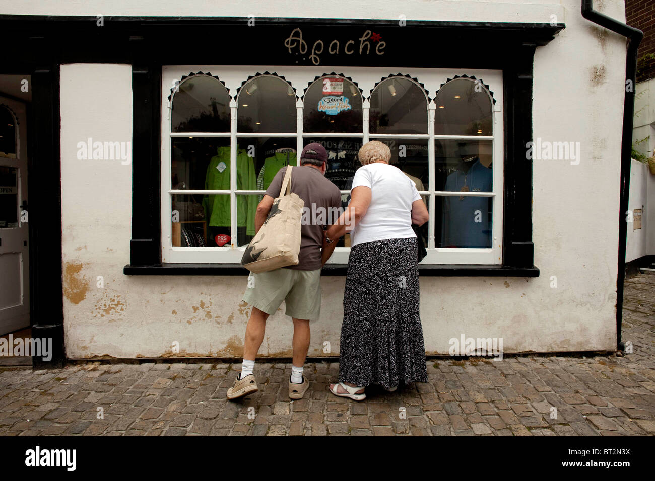 Un couple marié, la maintenant sur l'autre, comme ils vont faire du shopping dans la fenêtre Hampshire Ville de Lymington. DAVID MANSELL Banque D'Images