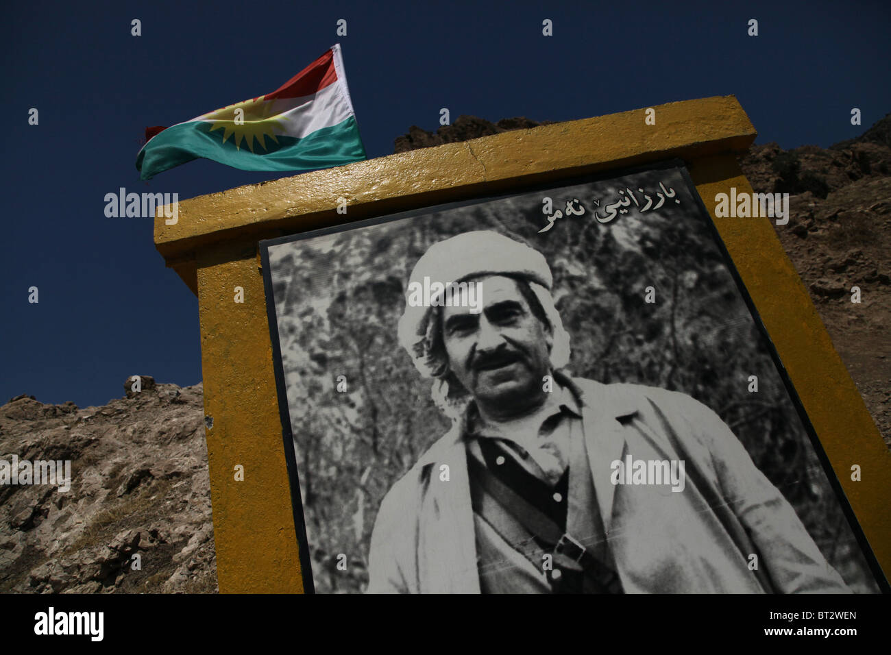 Brandir le drapeau kurde sur un monument de la route portant le chiffre de Mustafa Barazani leader historique dans le Nord de l'Iraq Banque D'Images