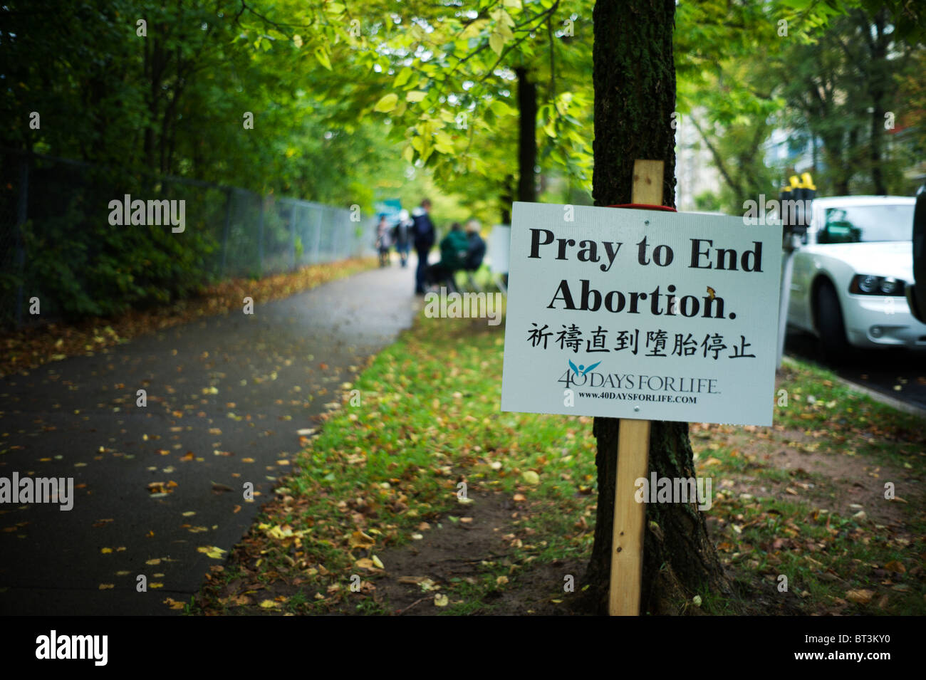 Signe anti-avortement et des protestataires sur trottoir bordé d'arbres. Banque D'Images