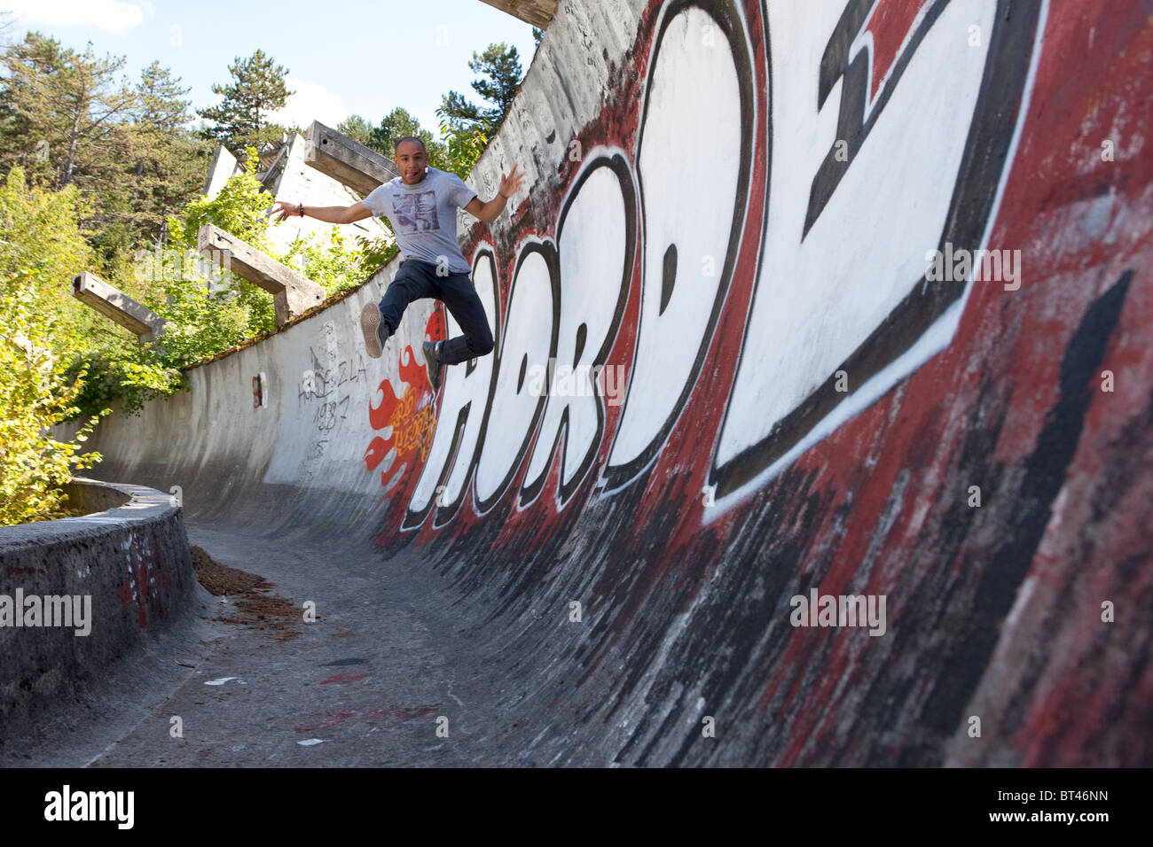 Un jeune mec saute la paroi latérale de la piste de bobsleigh de Sarajevan les Jeux Olympiques d'hiver de 1994. Banque D'Images