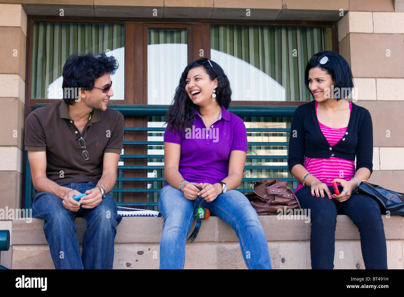 Les élèves assis sur un mur, parler et rire, de nouveaux campus, Université américaine du Caire, Egypte Banque D'Images