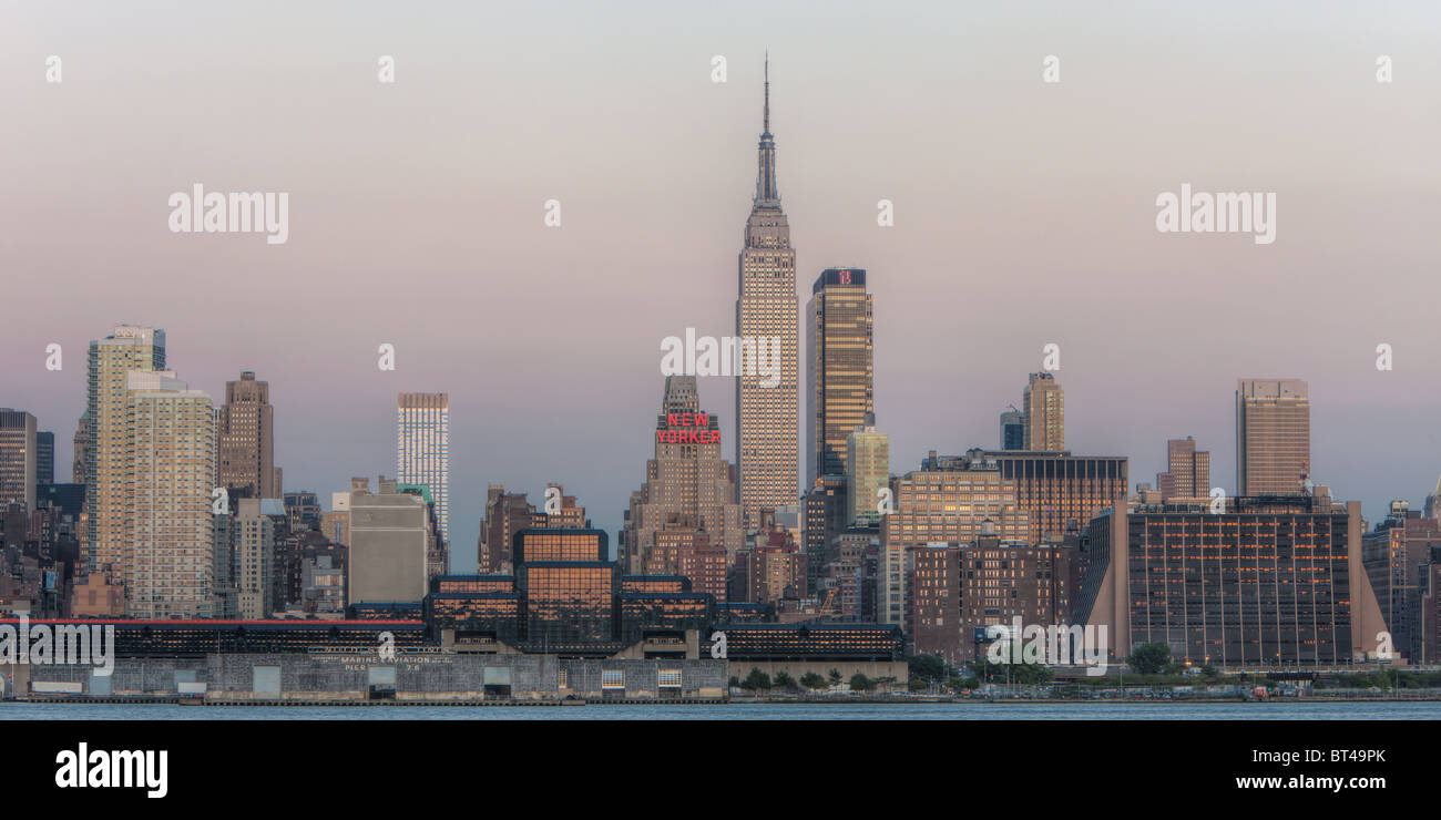 L'Empire State Building et Manhattan skyline au crépuscule avec la lueur orange du ciel de l'ouest reflètent dans les fenêtres de la ville de New York. Banque D'Images