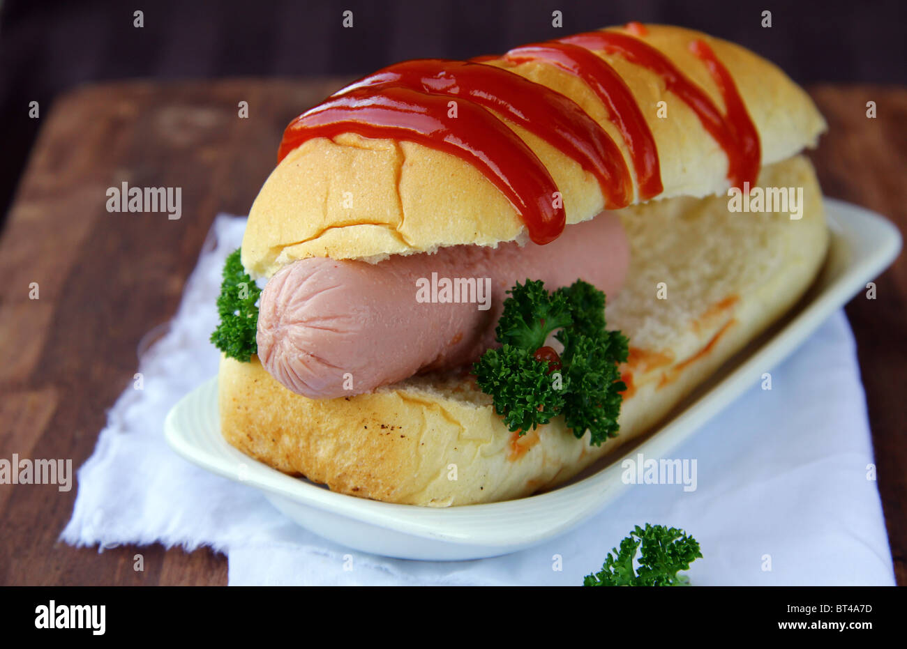 Hotdog sur une plaque sur un bureau en bois brun Banque D'Images