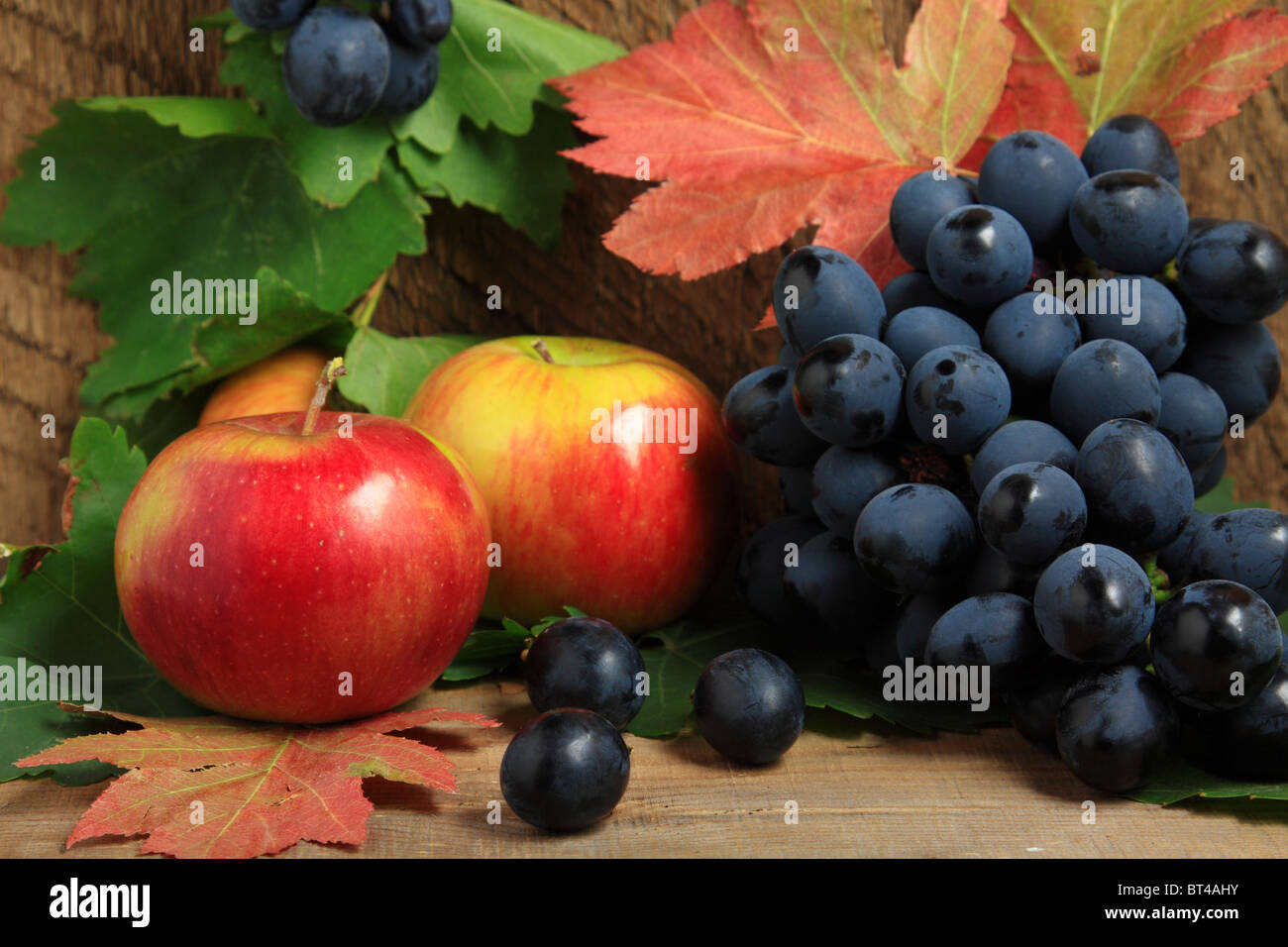 Nature morte avec pommes mûres et grappe de raisins sur bois Banque D'Images