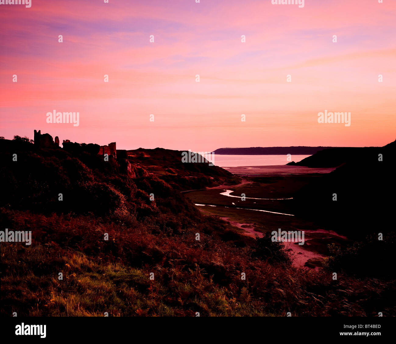 Coucher de soleil sur le château de Pennard et trois falaises bay. La péninsule de Gower. Banque D'Images