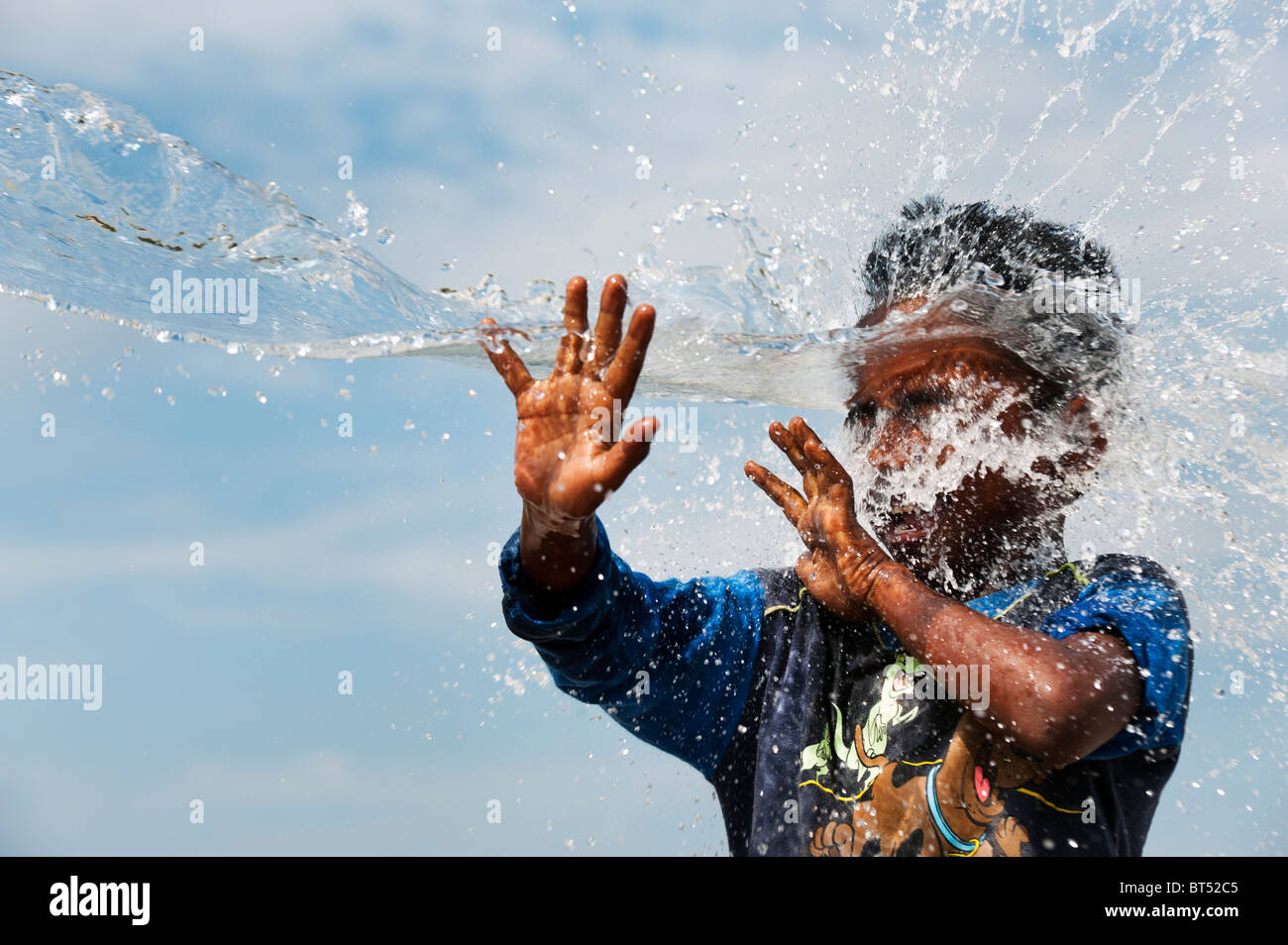 Jeune Indien éclaboussé avec de l'eau. L'Inde Banque D'Images