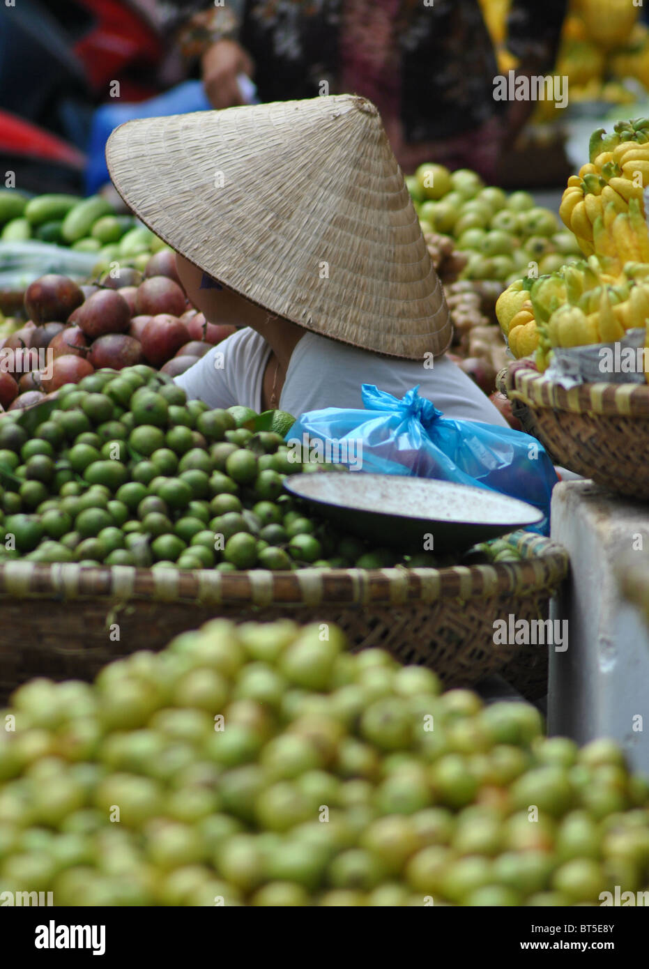 Fille vietnamienne vente de fruits sur un marché à Hanoi, Vietnam Banque D'Images