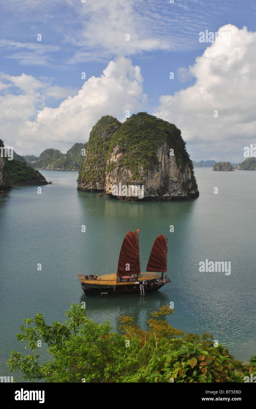 Junk avec voile rouge dans la baie d'Halong, Vietnam Banque D'Images