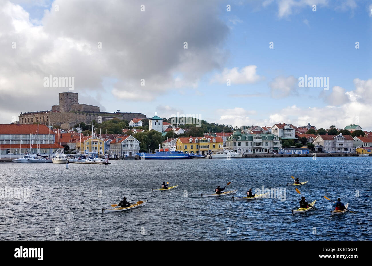 Un groupe de kayakistes de mer pagaie en face de Marstrand town, une destination touristique sur la côte ouest de la Suède. Banque D'Images