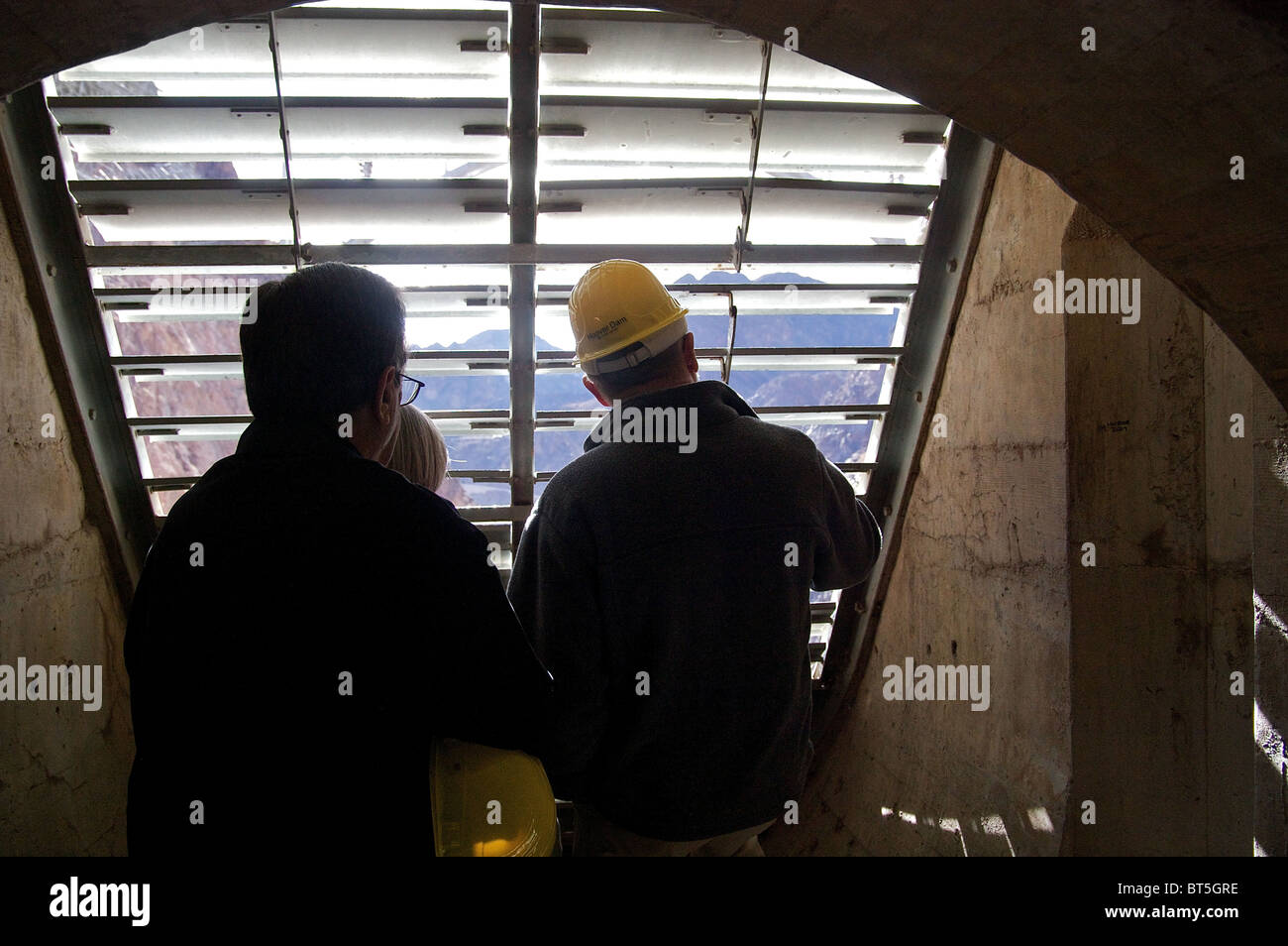 Les gens sur une visite guidée à l'intérieur des installations du barrage Hoover, regarder dehors vers le barrage et du paysage Banque D'Images