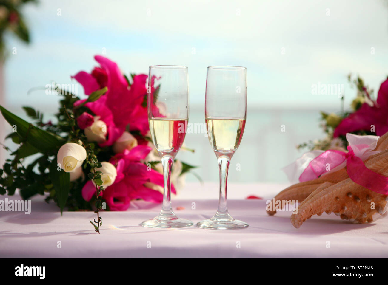 Deux verres de champagne sur une table lors d'un mariage à l'étranger. Des fleurs et une étoile de trop longs Banque D'Images