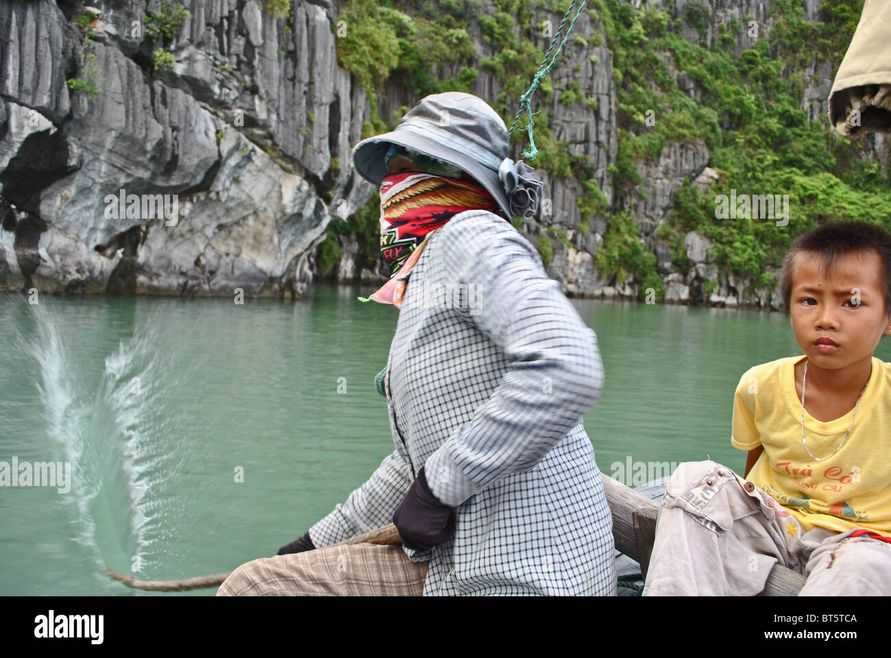 La mère et l'enfant en utilisant des méthodes traditionnelles de pêche dans la baie d'Halong, Vietnam Banque D'Images