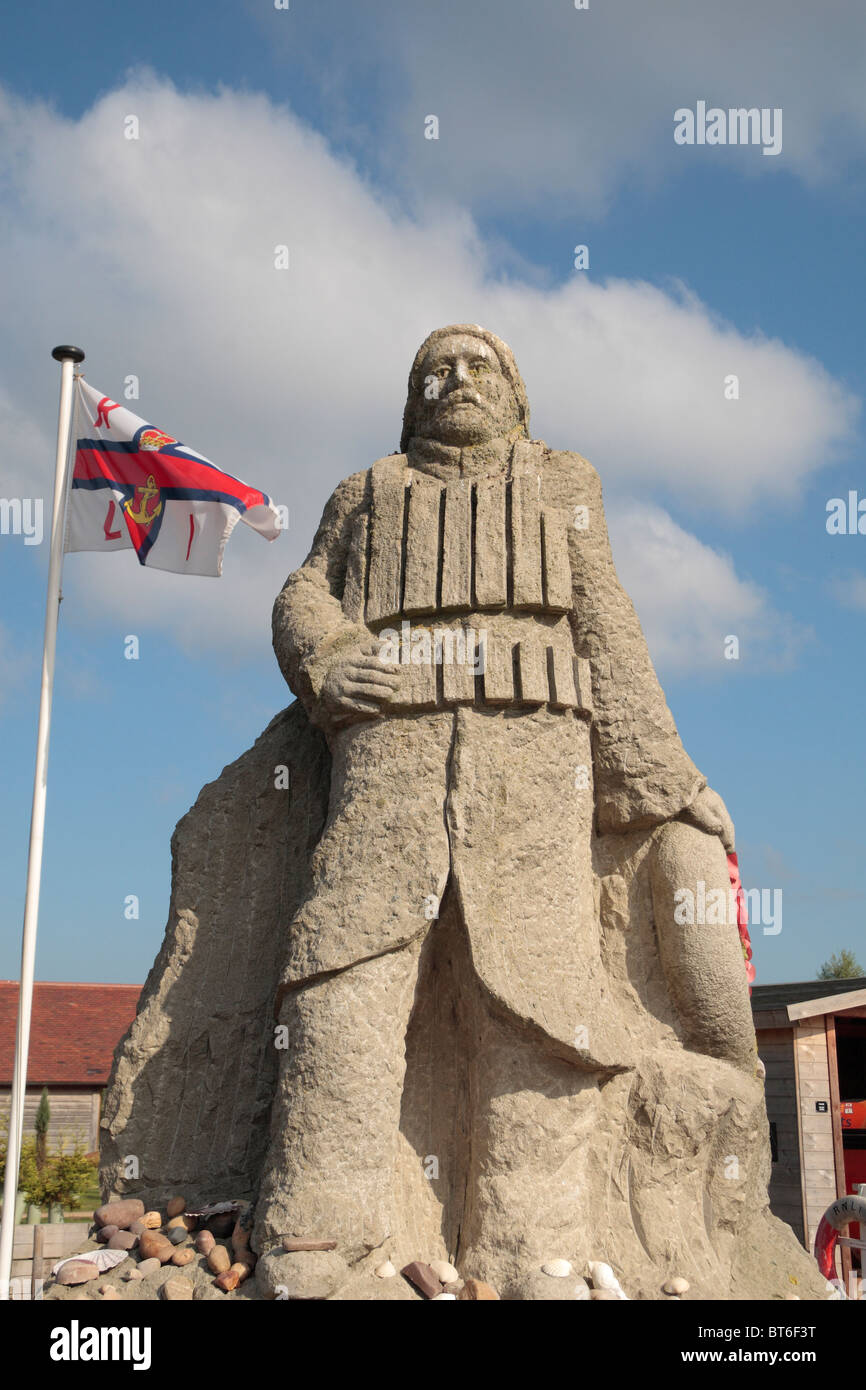 Statue et drapeau dans la la Royal National Lifeboat Institution memorial garden, National Memorial Arboretum, Alrewas, UK. Banque D'Images