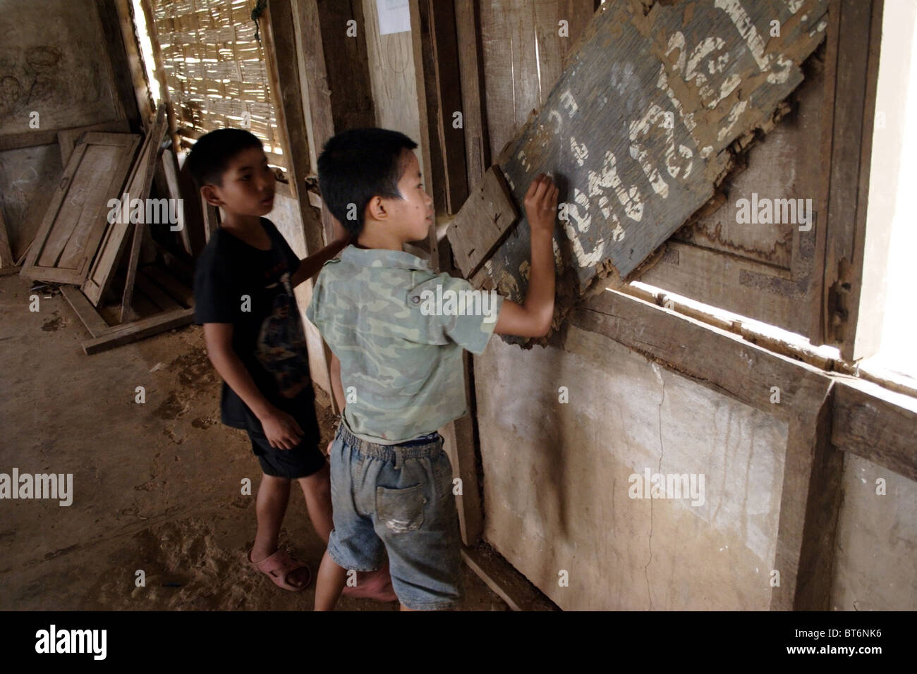 Deux garçons plus jeunes sont en train d'écrire sur un panneau en français dans une école primaire de Laos communiste. Banque D'Images